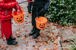 Two kids with Halloween buckets trick or treating