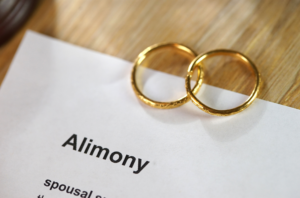 two wedding rings sitting on an alimony paper.