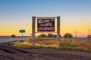 Welcome to Colorado sign with road in the background. 