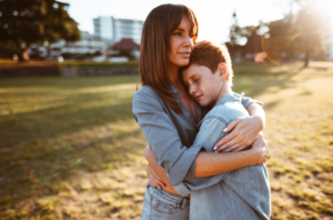 Child hugging mom in a field representing child custody.