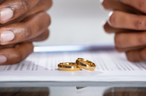 couple with wedding rings off on top of divorce papers
