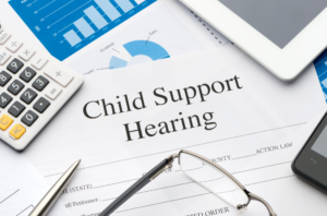 Child support hearing document with calculator, glasses, and pen on top of it.