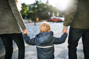 A child holding the hands of his parents. 